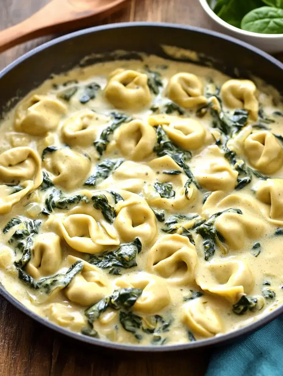A pan showing tortellini and spinach swimming in a rich, creamy sauce.